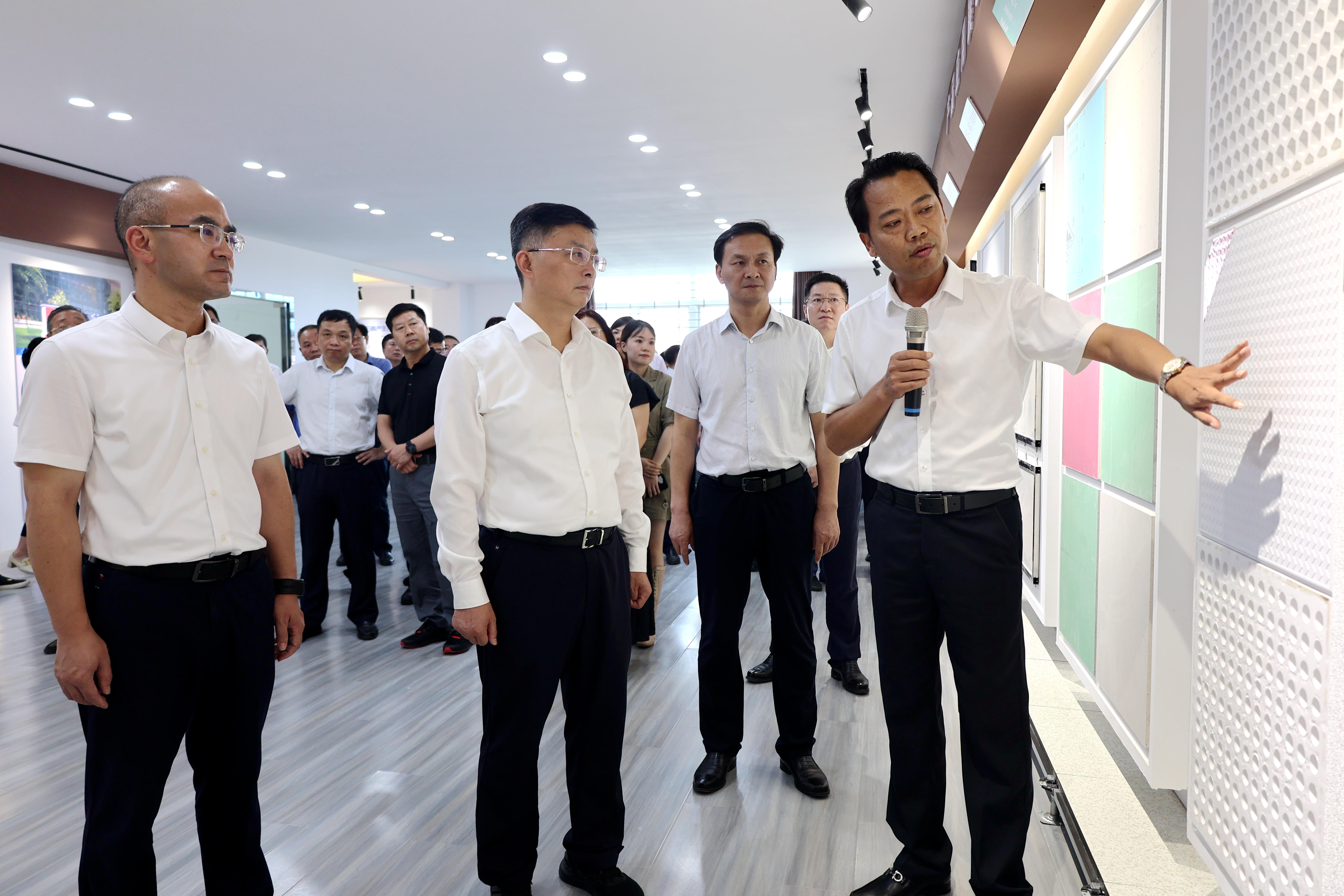 李维峰（前排右）正在向李涛（前排中）、江稳（前排左）等领导介绍磷石膏制各类产品.jpg